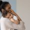 Mother holding infant child in a tender embrace. 